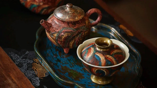 A set of urushi gaiwan and clay teapot sitting side by side on an urushi tea tray