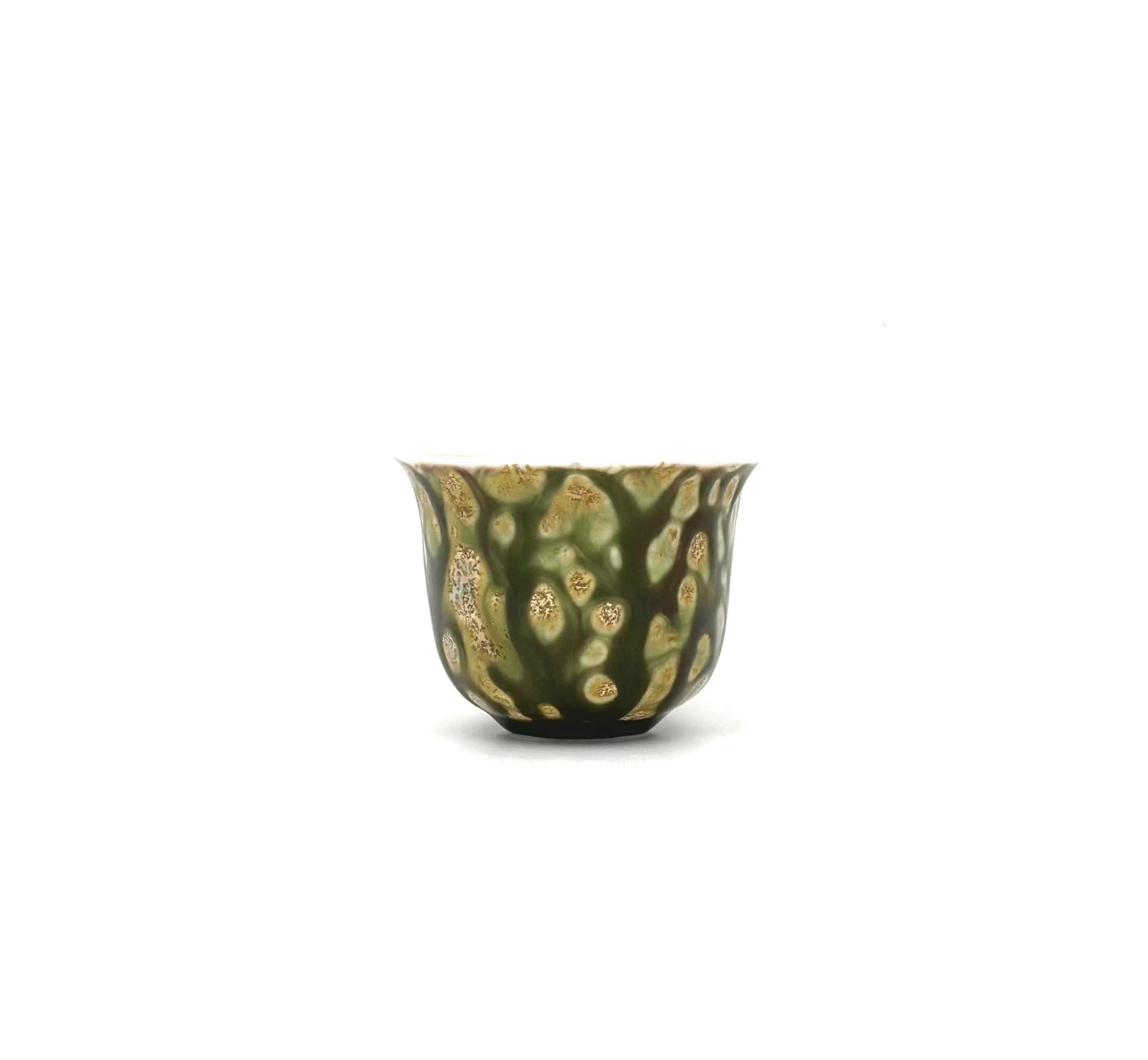 Small green ceramic cup with gold patterns on a white background