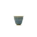 Ceramic cup with blue speckled pattern on a white background