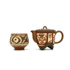 Earthstone teapot and teacup with decorative patterns on a white background