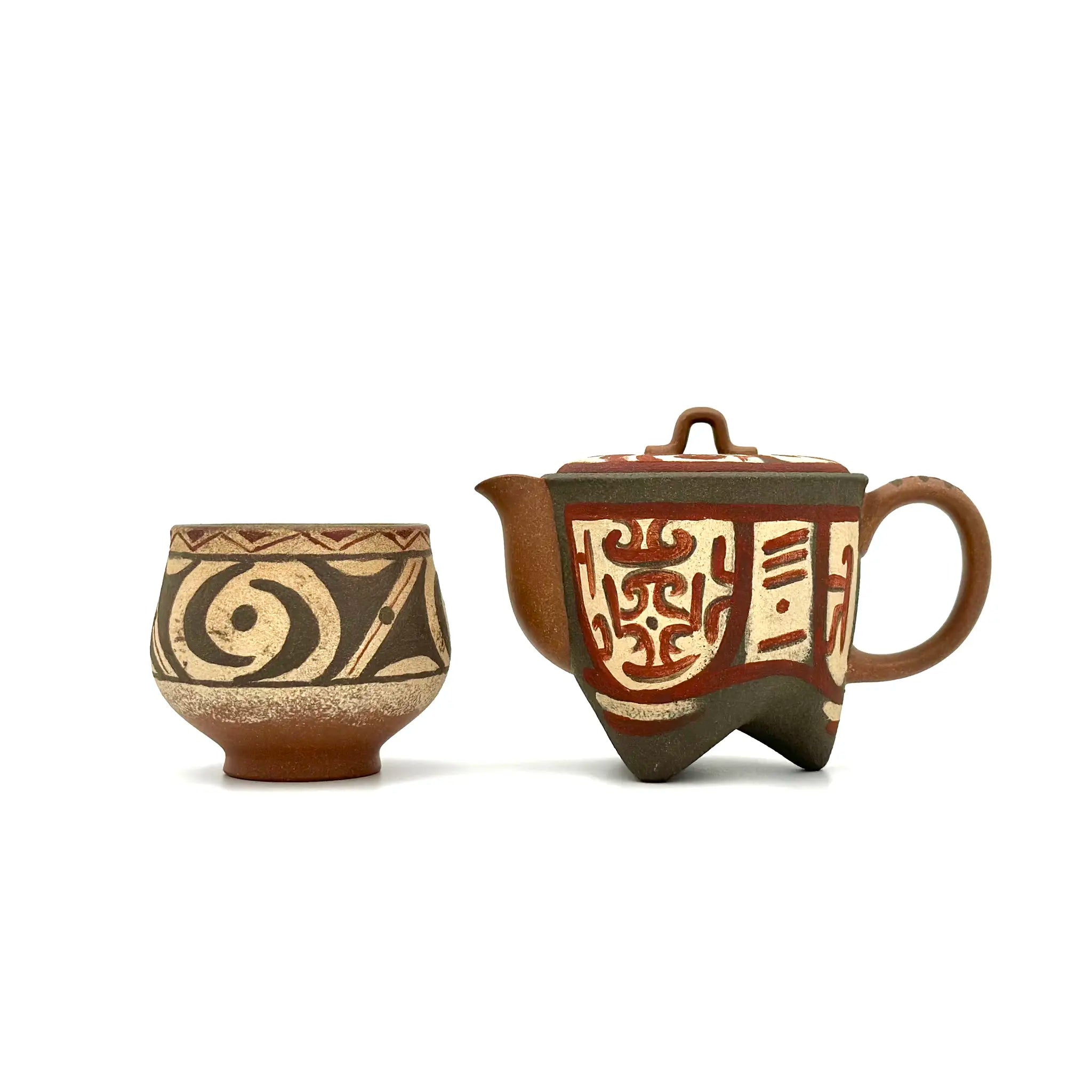 Earthstone teapot and teacup with decorative patterns on a white background