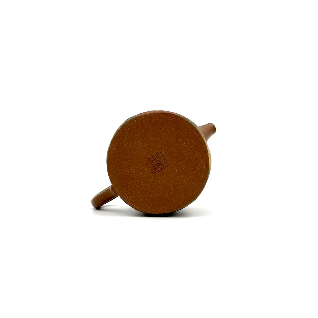 The unpainted base of the Desert Mirage Yixing teapot, displaying the authentic artisan's carved signature stamp against the natural texture of the clay.