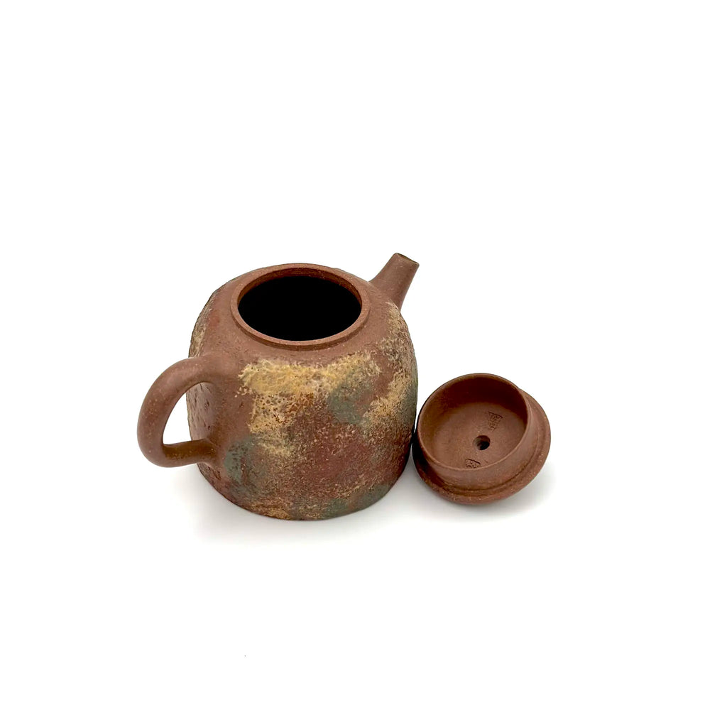 High-angle view of the open Desert Mirage Yixing teapot with its lid resting alongside, detailing the precise inner rim craftsmanship and the artisan's signature stamp inside the lid.