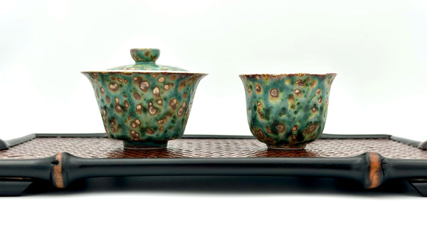 Complete Gongfu tea setup: Aurora Shore Gaiwan and master cup placed on a serving tray, ready for brewing loose leaf tea. Highlights the artisanal texture against a bamboo weaving tea tray.