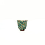 Small ceramic teacup with floral pattern on a white background