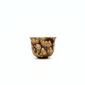 Small ceramic teacup with a unique brown and beige pattern on a white background