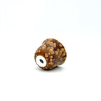 Brown and beige textured cup laying on a white background