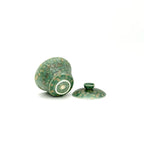 showcasing the bottom artisan's signature and glaze of a porcelain gaiwan, featuring a decorative pattern on a white background