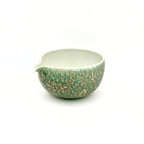 Angled view of the Emerald Drift artisan matcha bowl, highlighting the wide, gently curved mouth and smooth interior wall explicitly designed to provide ample room for whisking ceremonial tea.