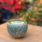 Beautiful latte art displayed inside the Glazara Emerald Drift matcha latte cup, showcasing the wide café-style bowl cpu and dynamic, ocean-inspired green ceramic glaze.