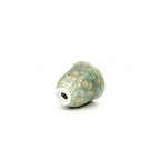 Decorative ceramic teacup with beige speckles on a white background