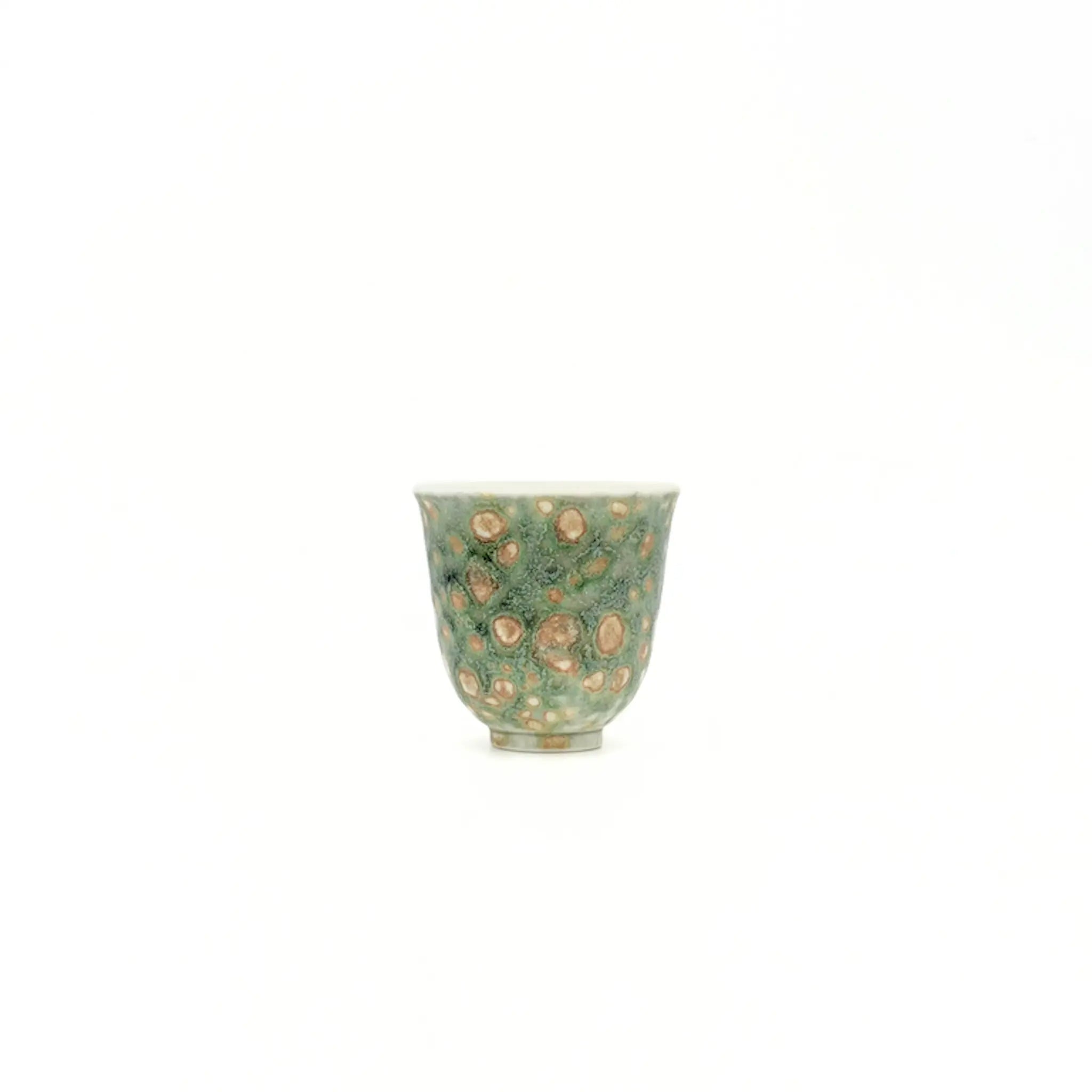 Green ceramic cup with beige speckles on a white background