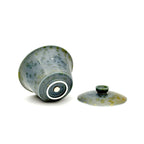 Showcasing the bottom artisan's signature and glaze of a porcelain gaiwan, featuring a decorative pattern on a white background