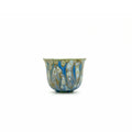Decorative porcelain teacup with blue and gold patterns on a white background