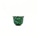 Ceramic teacup with a speckled design on a white background