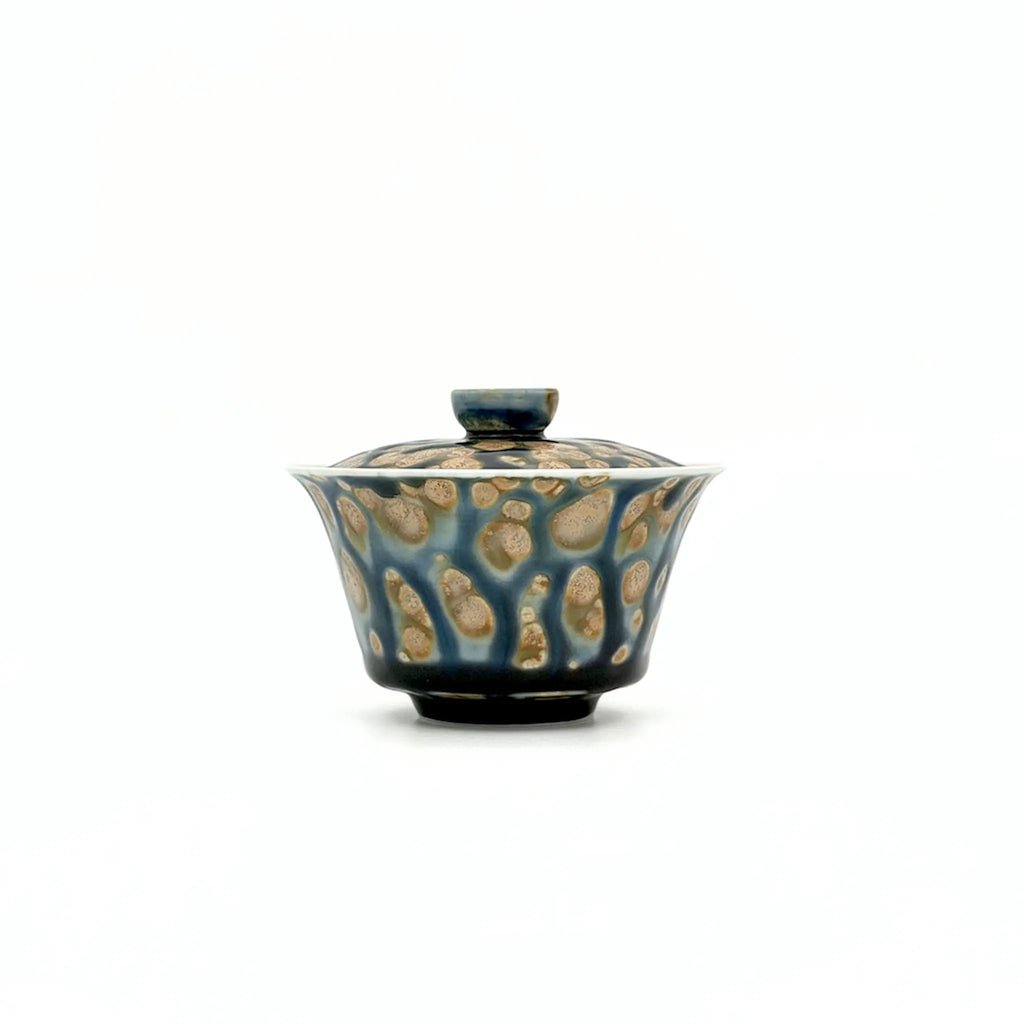 Porcelain gaiwan with a textured surface on a white background