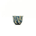 Ceramic cup with blue and gold pattern on a white background