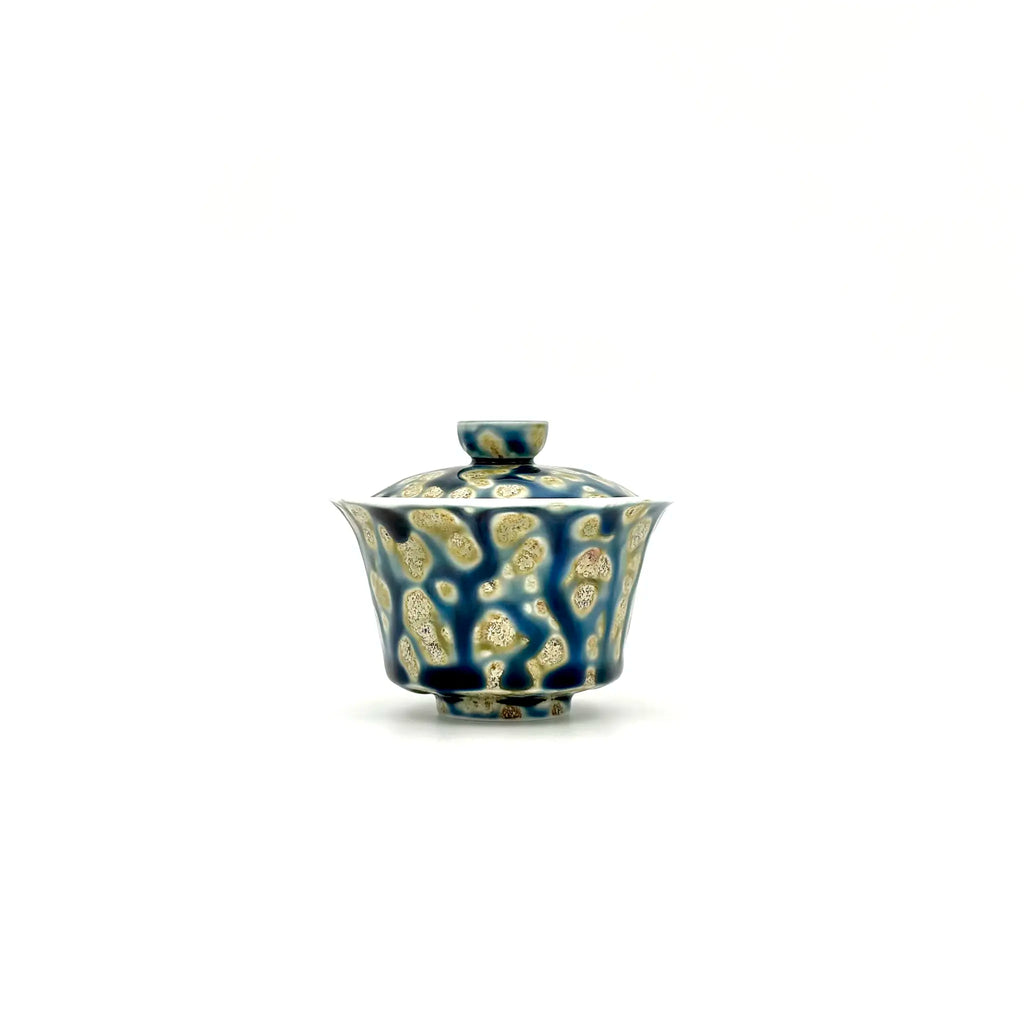 Ceramic gaiwan with lid featuring a blue and gold pattern on a white background