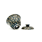 Showcasing the bottom artisan's signature and glaze of a porcelain gaiwan, featuring a decorative pattern on a white background