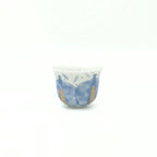 Ceramic cup with blue and gold design on a white background