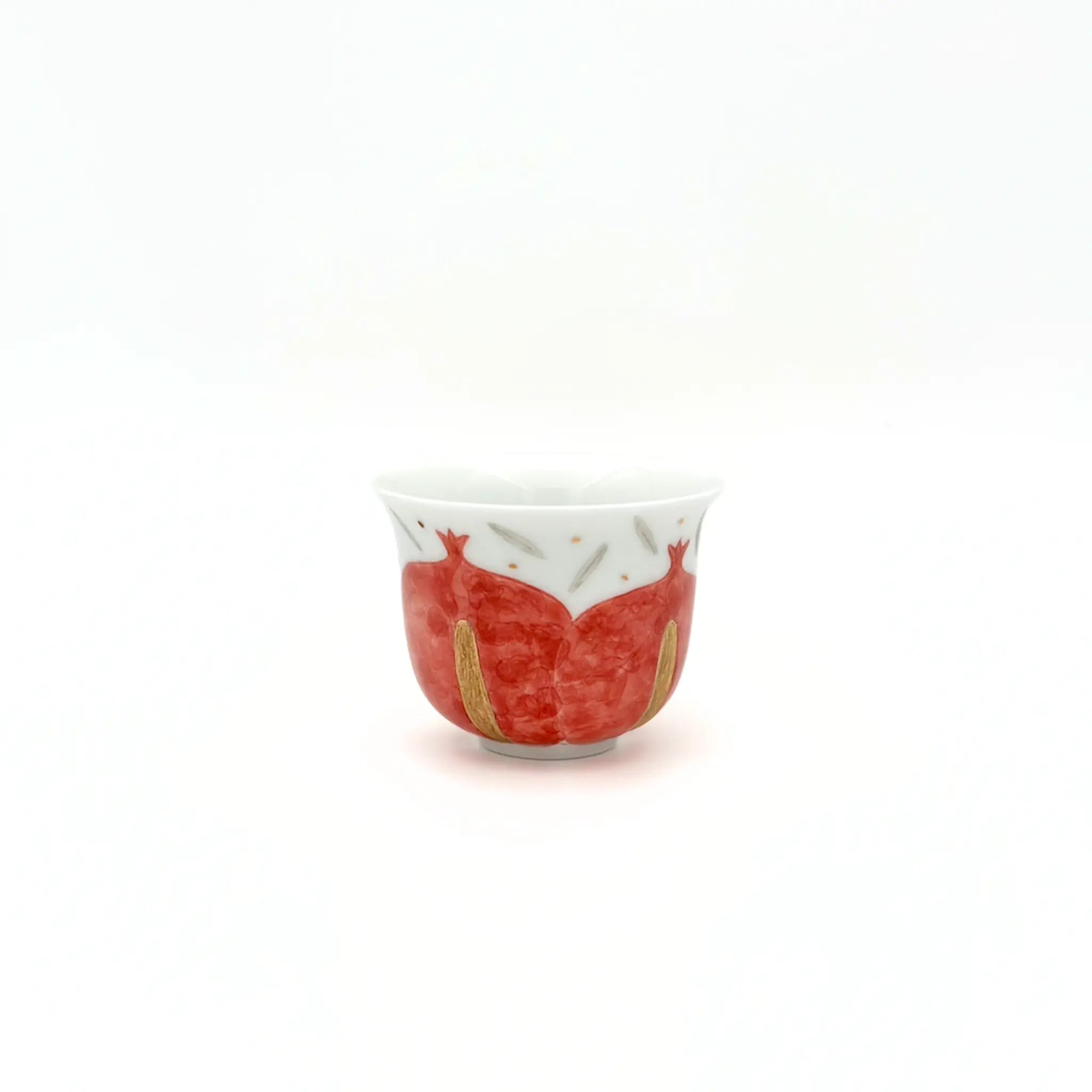 Small ceramic cup with red and gold design on a white background