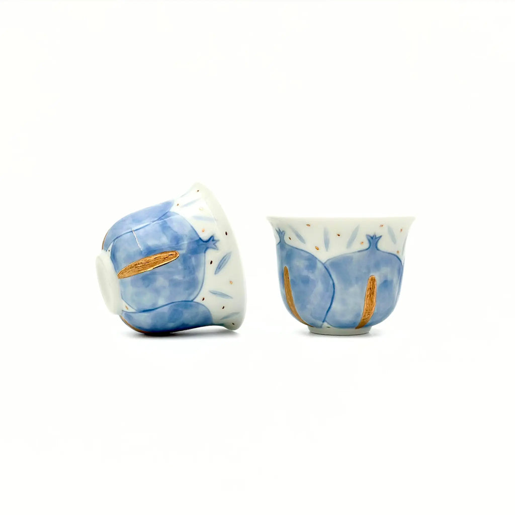 Two ceramic teacups with blue and white design on a white background