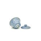 Blue ceramic gaiwan with a pattern on a white background