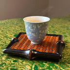 Atmospheric lifestyle view of the 30ml Glazara Promenade Breeze tasting teacup gently steaming on a traditional bamboo tea tray, capturing a serene and authentic Gongfu tea brewing moment.