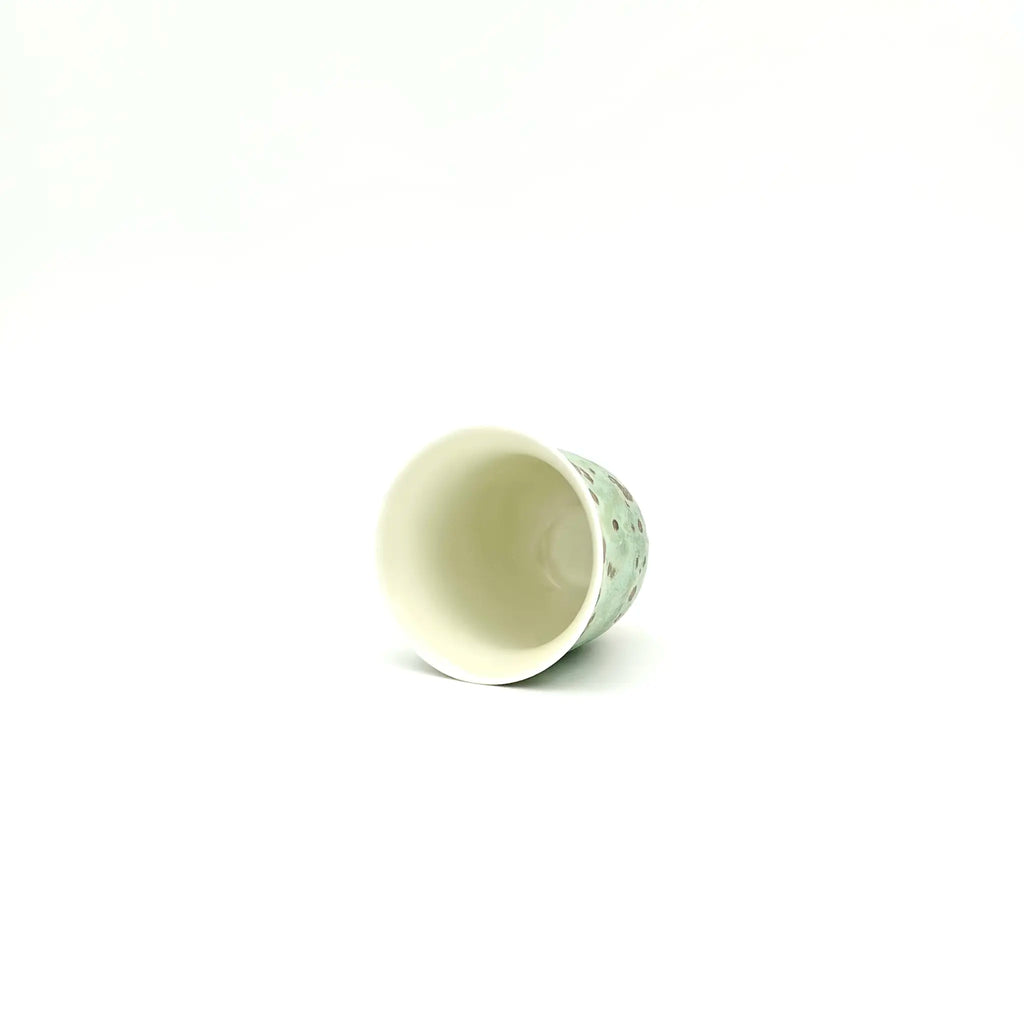 The porcelain teacup with pure interior glaze design on a white background.