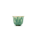 Green ceramic cup on a white background