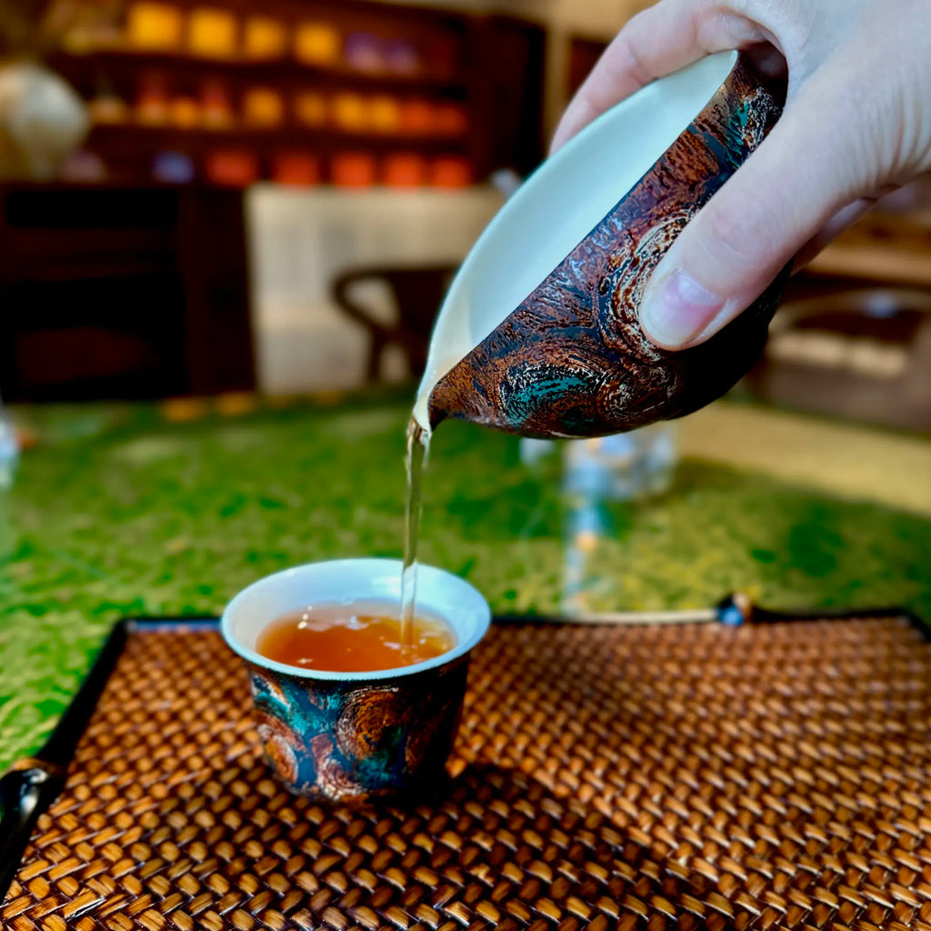 Lifestyle view of the Glazara Vintage Flora 70ml porcelain Gongfu teacup resting on a bamboo woven tray, bringing Eastern tea culture and artful living into modern homes.