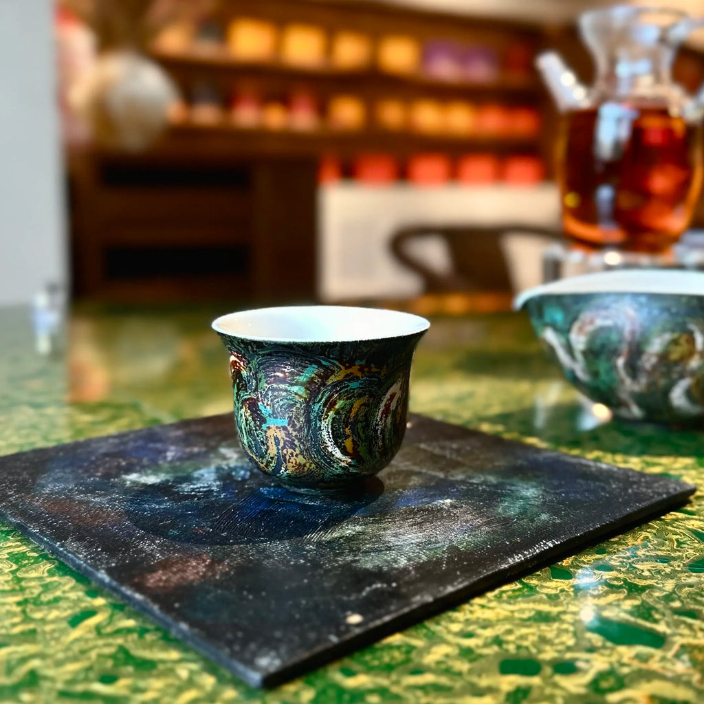 Lifestyle view of the fine porcelain Glazara Viridian Twilight 70ml Gongfu teacup resting gracefully on a lacquer tray, blending modern interior design with fine tea culture.