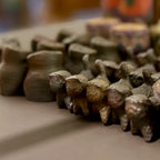 Close-up of small wood figurines on a neutral surface with blurred background