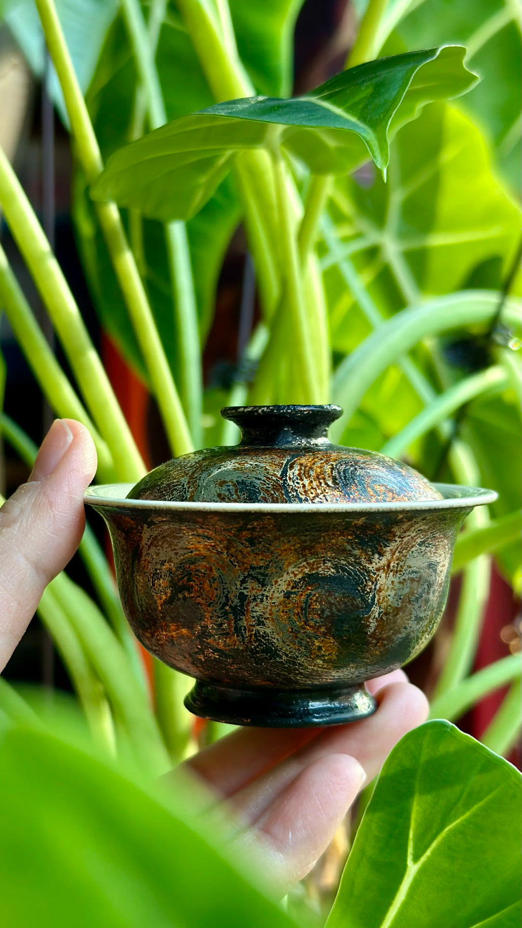 A close up of the 60ml Midnight gaiwan held in hand for a solo tea session.