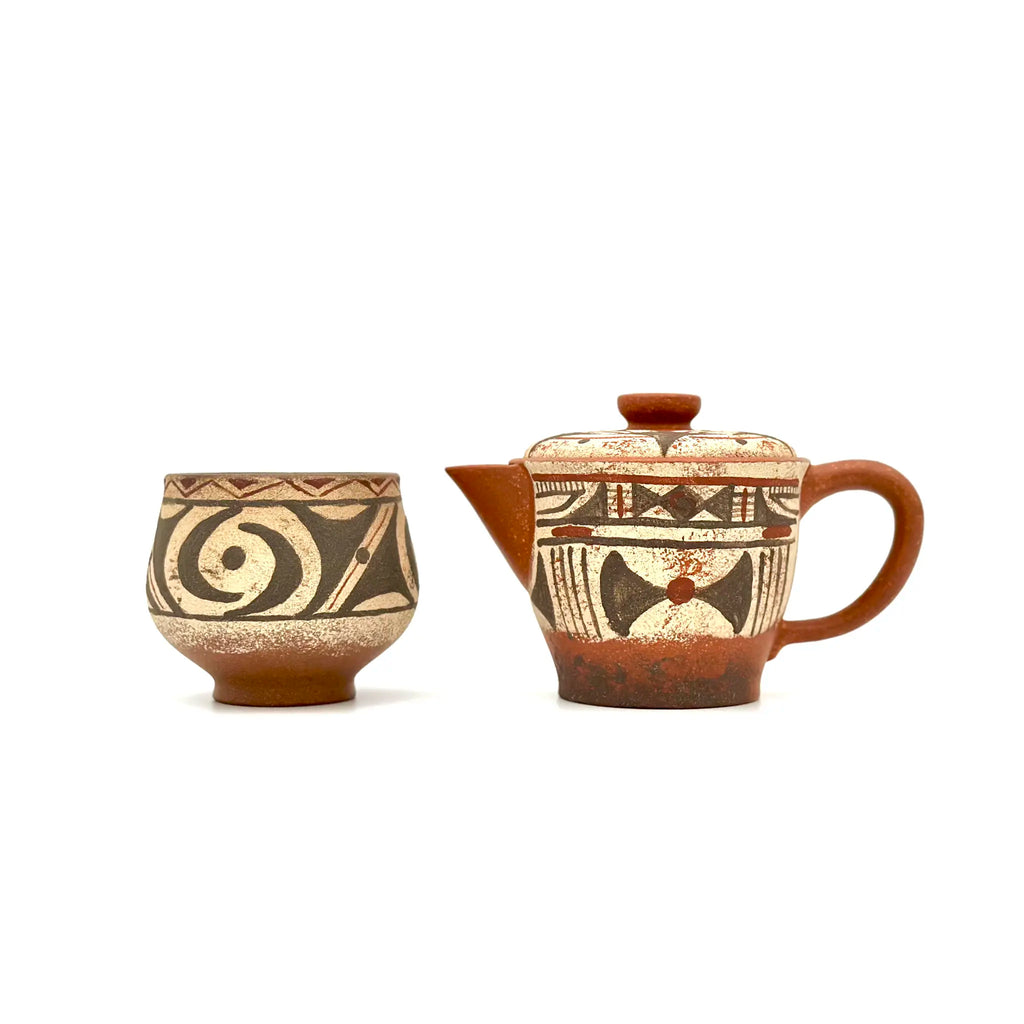 Earthstone teapot and cup with geometric patterns on a white background