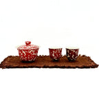 A professional studio photograph of the complete Phoenix Spark Chinese Wedding Tea Set, showing the gaiwan and two tasting teacups arranged on a traditional tea mat against a white background.