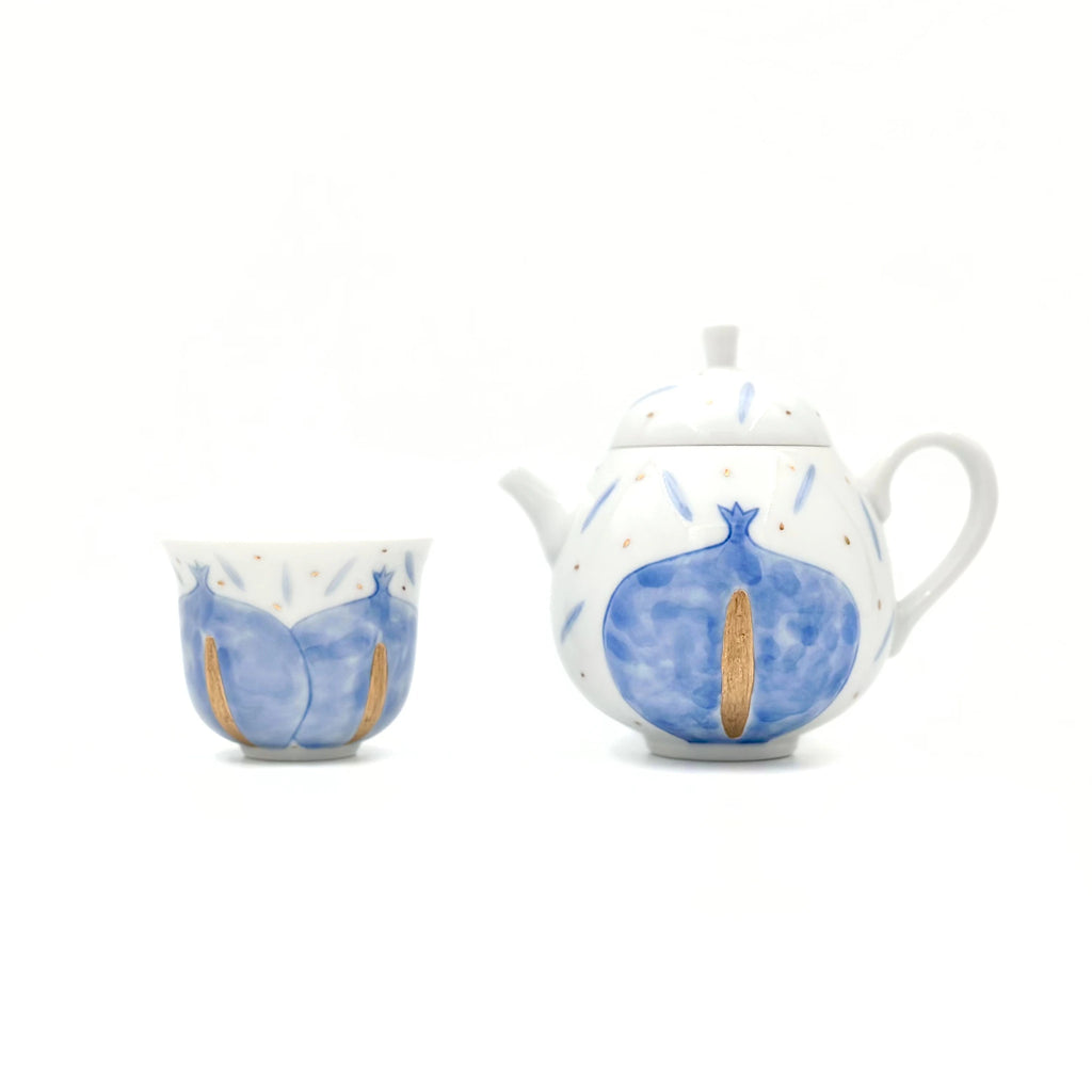 Ceramic teapot and cup with blue and white design on a white background