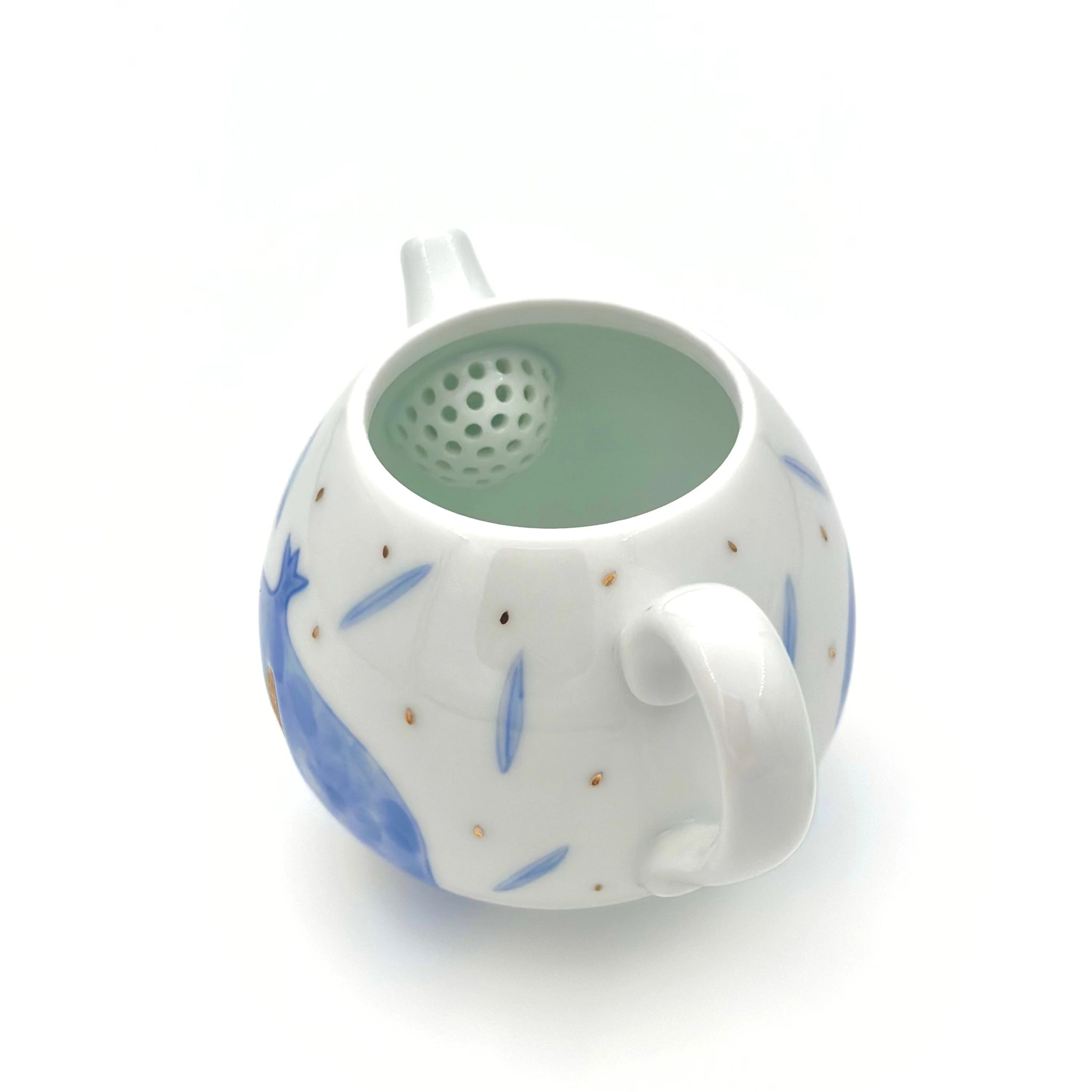 White ceramic tea infuser with blue floral patterns on a white background