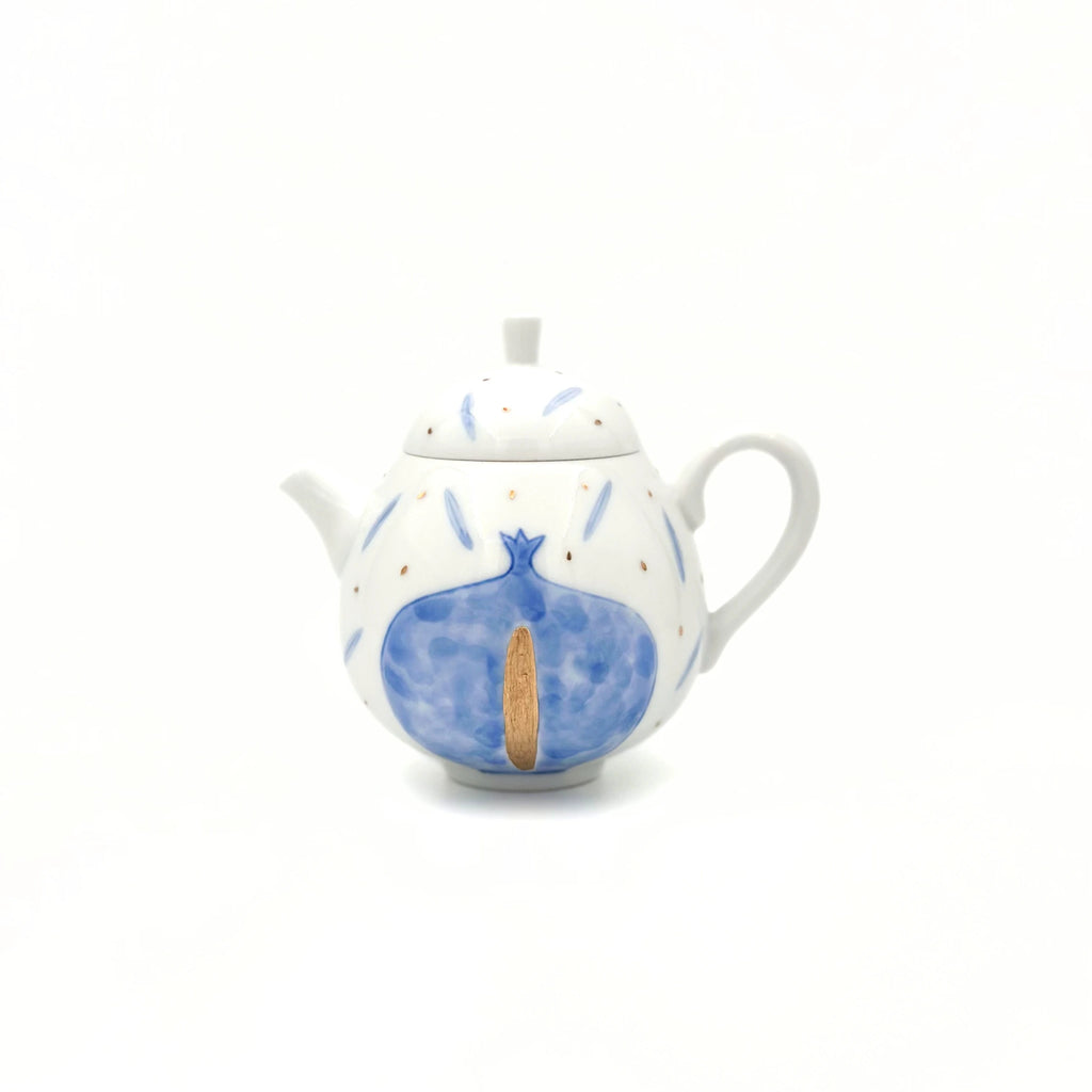 Ceramic teapot with blue pomegranate design on a white background