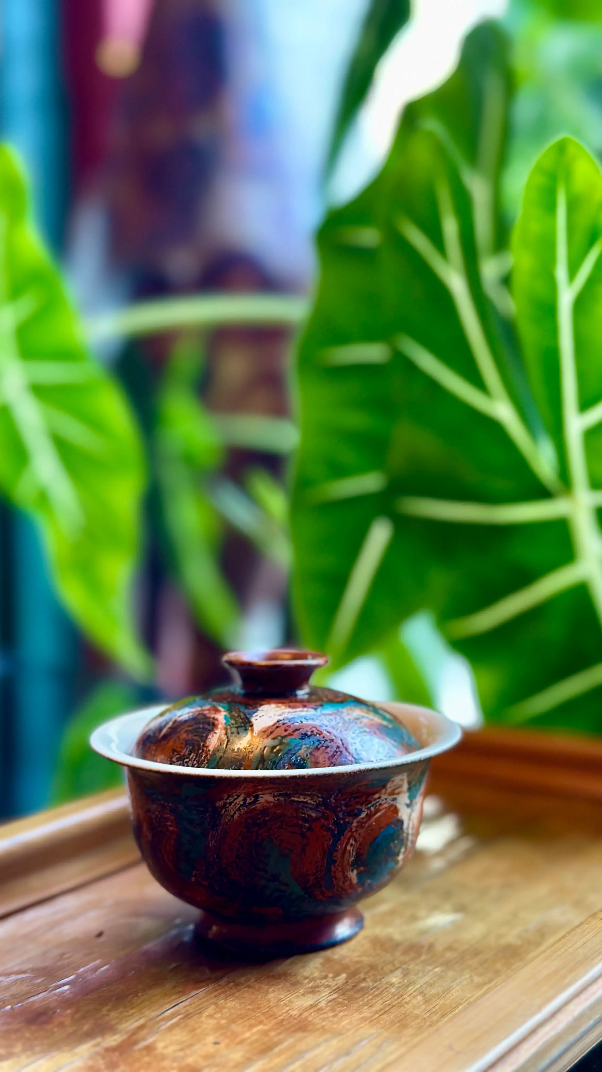 The Vintage Flora gaiwan presented on a bamboo tray against a natural green plant background.